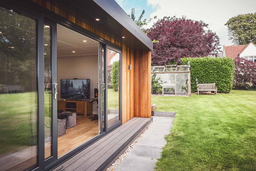 view of garden room with sliding door in garden