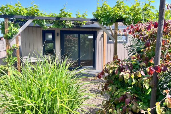 view of garden room wellness studio at bottom of garden